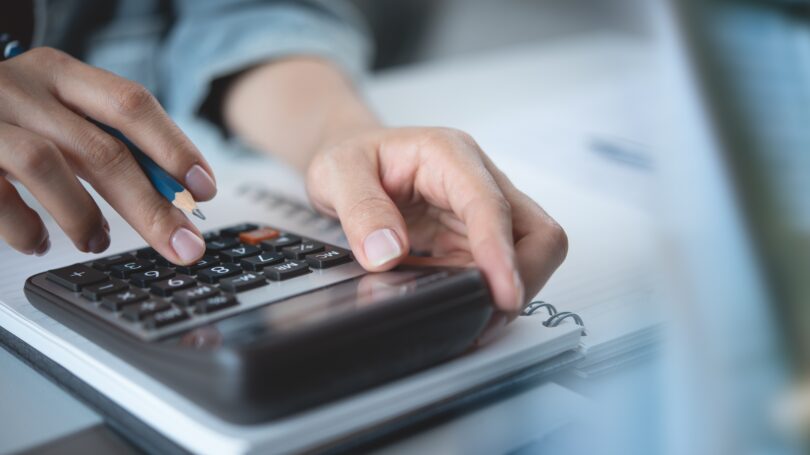 Hands type on a calculator